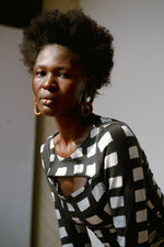 Model wearing Osei-Duro Rift Top in Dominos batik print, featuring cut-out details and a black and white pattern.