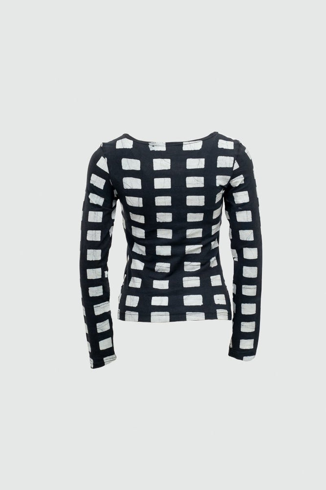 Long-sleeved Osei-Duro Rift Top in Dominos batik print, featuring a black and white grid print against a neutral background.