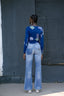 Back view of a person wearing the Rift Top in Location print and blue jeans, showcasing the unique print fabric.