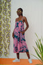 Full-length view of a model wearing the Saya Dress in Pool Party print, standing against a patterned backdrop.