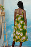 Back view of a person wearing the Saya Dress in Waters print, standing next to a wooden ladder with a basket of flowers.