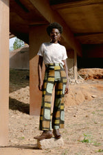 High-waisted Veronica Trousers in Pistacia batik print, showcased in a natural outdoor setting for a relaxed look.