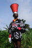 Unisex Album Garment with intricate black and white patterns, styled with a red cone hat and white gloves.