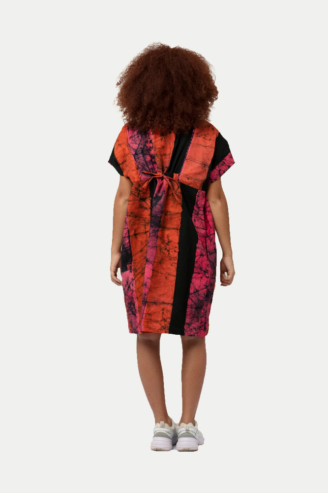 Knee-length Bata Dress in abstract Carmine print, paired with white sneakers for a modern twist.