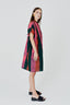 Loose Bata Dress in bold Carmine batik print with mandarin collar and sculptural silhouette.