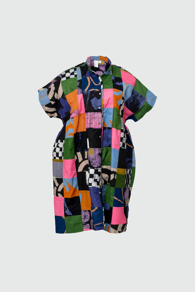 Vibrant patchwork Bata Dress in Motley, short sleeves, against a light backdrop, showcasing a mix of colorful prints.