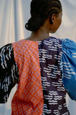 Unique top with blue, orange, and black sections. View of the back. Ethically made in Ghana.