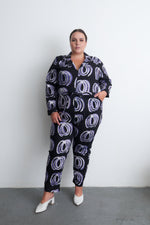 Stylish Accra Jumpsuit in Good Signal print, model with hand on hip, paired with white heels, against a plain backdrop.