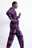 Woman in a dynamic pose in the Accra Jumpsuit in Love Perfect floral print, full-sleeve, waist drawstring, against white.