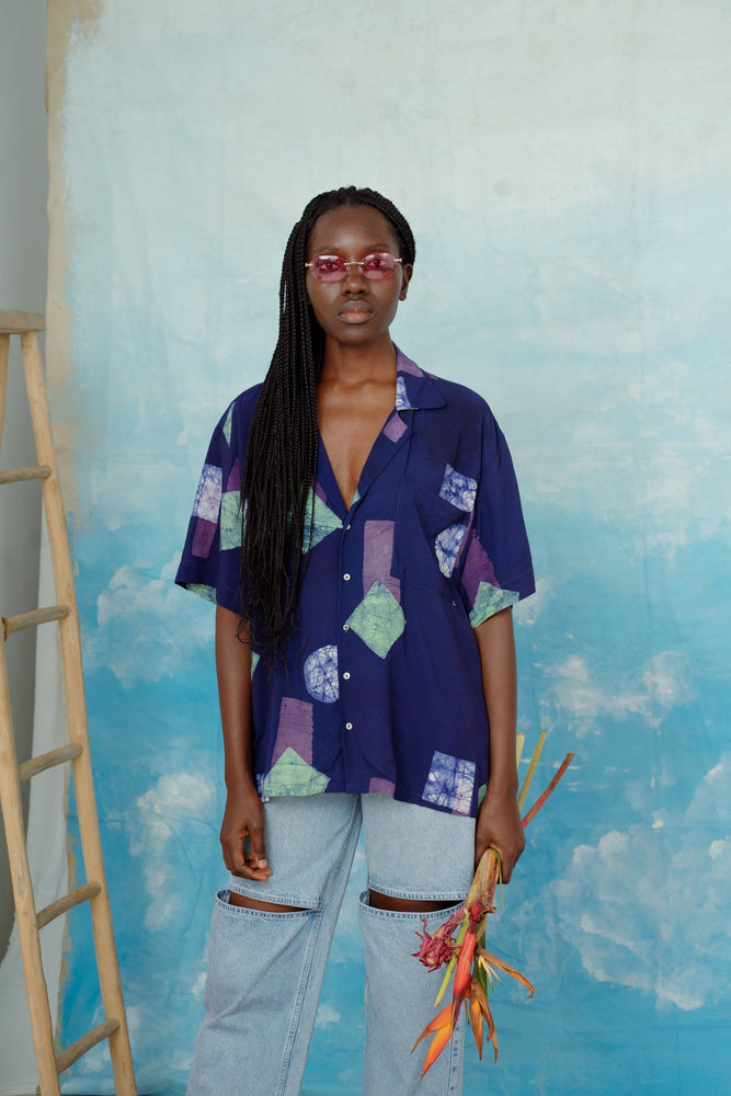 A casual unisex shirt made of rayon, featuring a classic Hawaiian style with dropped shoulders and an oversized front pocket.