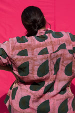 Close-up view of a size 3 rayon fabric texture, showcasing the pink print with dark green organic shapes on a soft material.