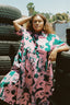 Imperium Dress in Pool Party print, poised against a tire stack backdrop, blending fashion with industrial charm.