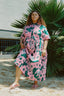 Imperium Dress in vibrant Pool Party print, outdoor setting with palm backdrop, embodying a fresh, summery look.