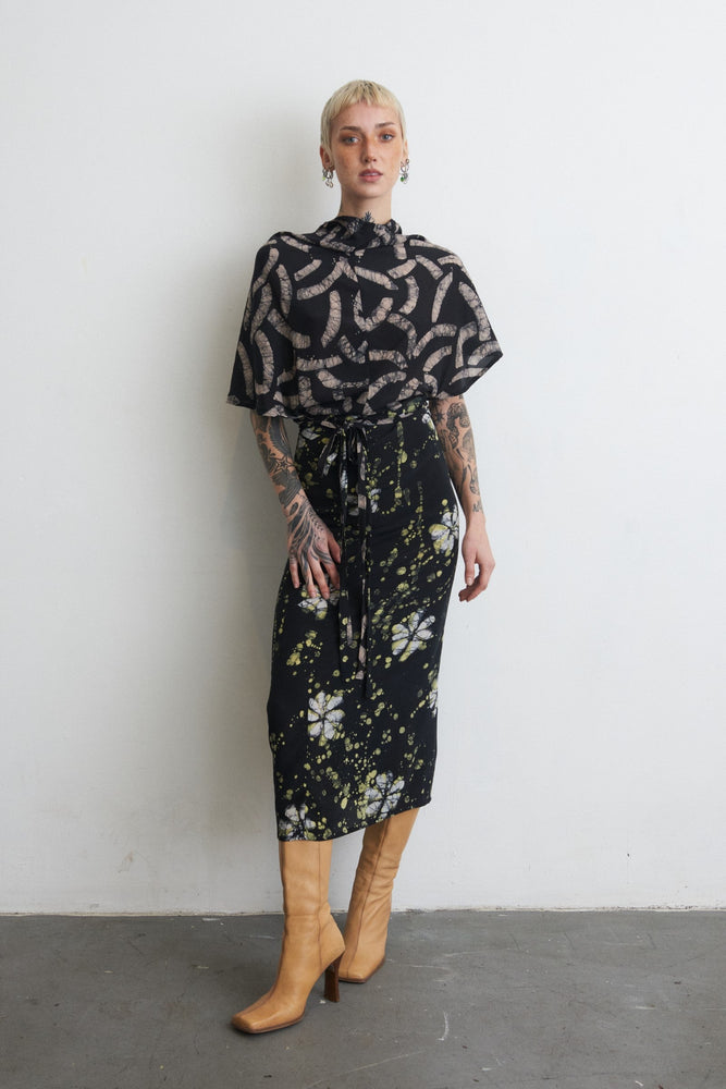 Chic Katharos Dress in Nap Time print, featuring patterned top and floral skirt with tie at the waist and knee-high boots.