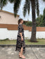 Side view of a woman wearing the Letsa dress, hand dyed with warm tan cantaloupe slice-like shapes on a black background.