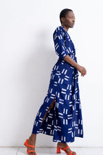 Letsa Dress in Middle Path print, blue with white patterns, paired with orange heels, against a white background.