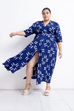 Dynamic Letsa Dress in Middle Path, blue with white patterns, captured in motion with white heels, against a plain backdrop.