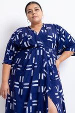 Letsa Dress in Middle Path print, wrap style with white line patterns on blue, tied at waist, against a white backdrop.