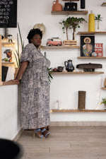Nonna Dress in Snakebite pattern, stylish indoor setting with decorative shelves, perfect for a modern minimalist look.