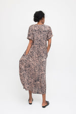 Nonna Dress in Snakebite print, viewed from back, mid-length with short sleeves, and black flats on white backdrop.