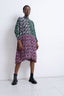 Patterned Para Dress with green and pink accents, paired with black boots, against a white backdrop, exuding chic style.