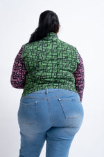 Rear view of a green and black patterned top with long sleeves, paired with classic blue jeans against a white backdrop.