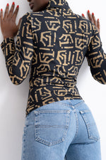 Person in a unique Stricta Turtleneck with abstract pattern, paired with denim jeans, creating a bold style statement.