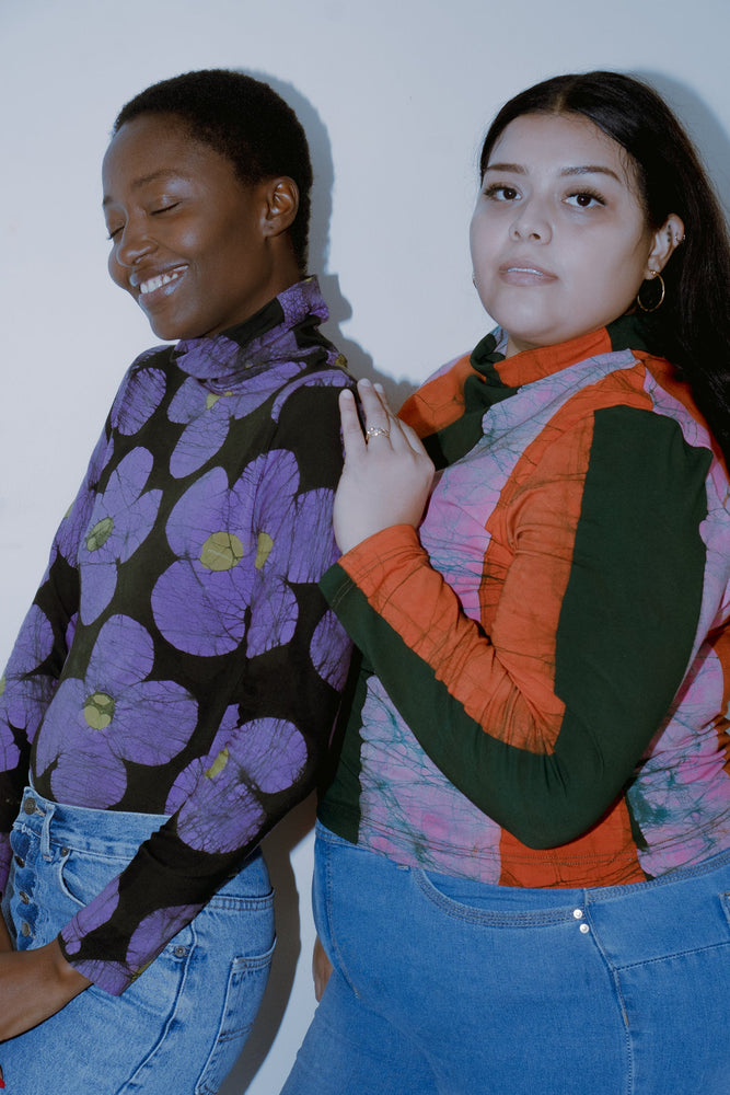 Two individuals showcasing their style in the colorful, patterned Stricta Turtleneck in Love Perfect batik print.