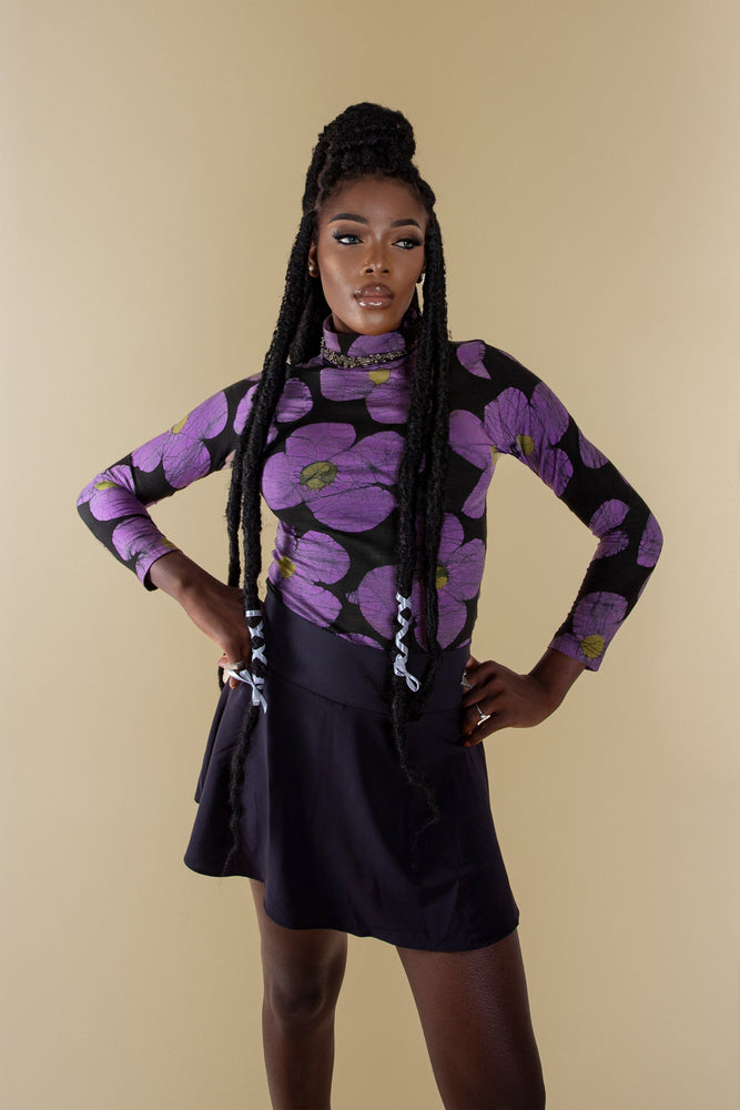 Person in a stylish outfit featuring the **Stricta Turtleneck in Love Perfect print** with its vibrant floral pattern.