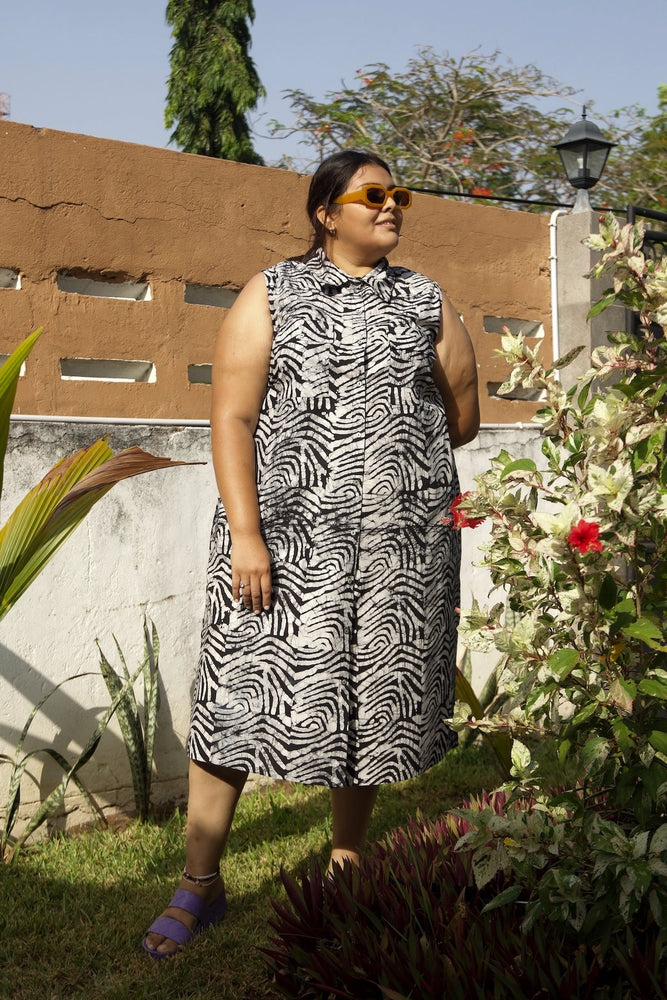 A woman wearing the Tropicana cotton dress in the black and white Long Division print in size 2X.