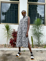 The dress's loose silhouette is emphasized, the black and white zebra-stripe pattern adds a bold touch to the overall look.