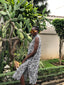 The model is standing in front of cacti, showcasing the dress's flowy skirt and fitted silhouette.