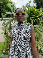 A woman wearing the Tropicana Dress in Long Division, showcasing the garment's unique black and white zebra-stripe pattern.
