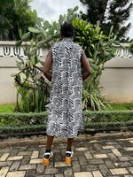 Back view of a person wearing a black and white batik print cotton shirtdress stands in front of cacti.