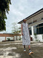 A woman wearing the Tropicana Dress walking down the street showcasing the dress's versatility.