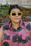 Portrait of a woman in the cotton Tropicana Dress, the print has a playful pink background with bold green organic shapes.