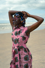 A woman on the beach in a sleeveless cotton shirtdress with a vibrant and eye catching batik print.