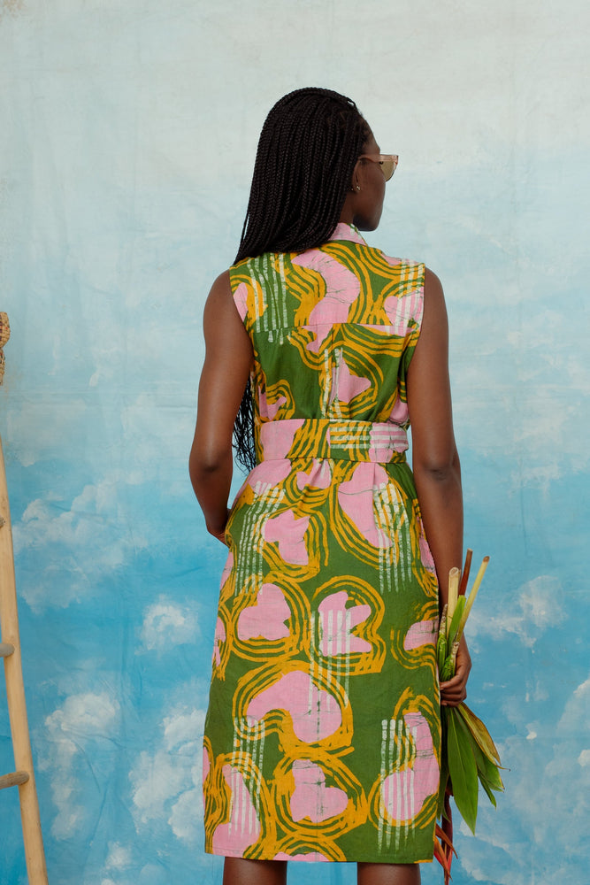 A back view of the dress, revealing a wide self fabric belt for an adjustable waistline.